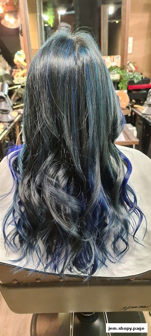 A person's back with long, wavy hair featuring blue and grey highlights.