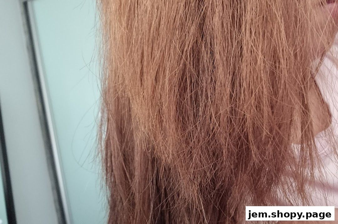Close-up of a person's long, light brown hair with a light blue background.