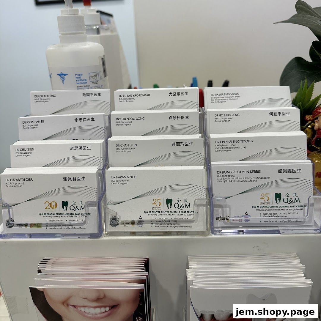 Business cards of dentists from Q & M Dental Centre displayed in a rack.
