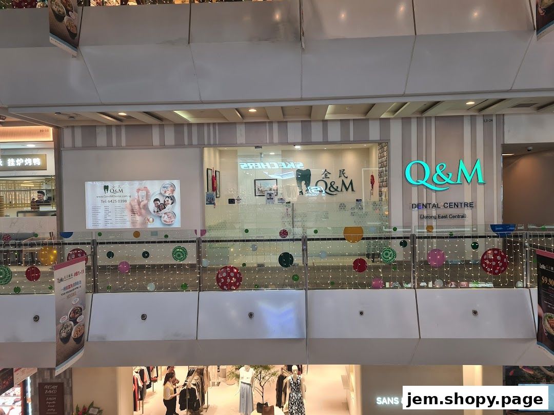 The exterior of Q&M Dental Centre at JEM-Jurong East, with signage and a display board.