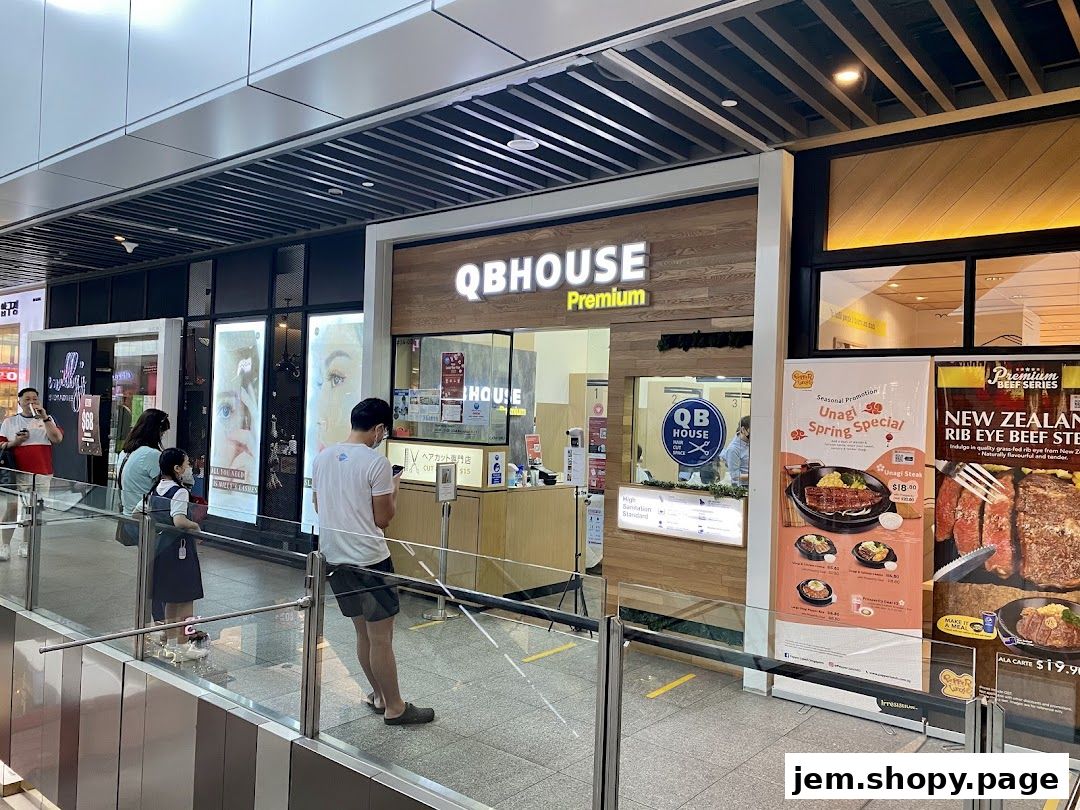 The exterior of QB Premium, a hair salon, with promotional posters for food items.