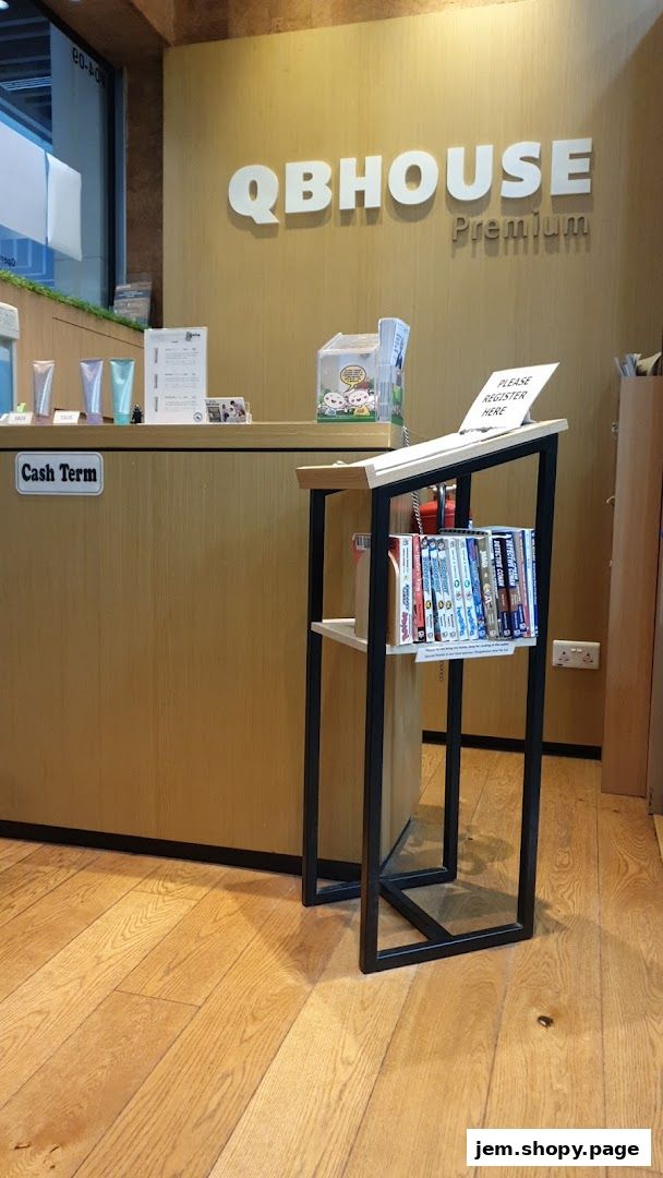 QB HOUSE Premium reception area with a counter, product display, and a small shelf with books.