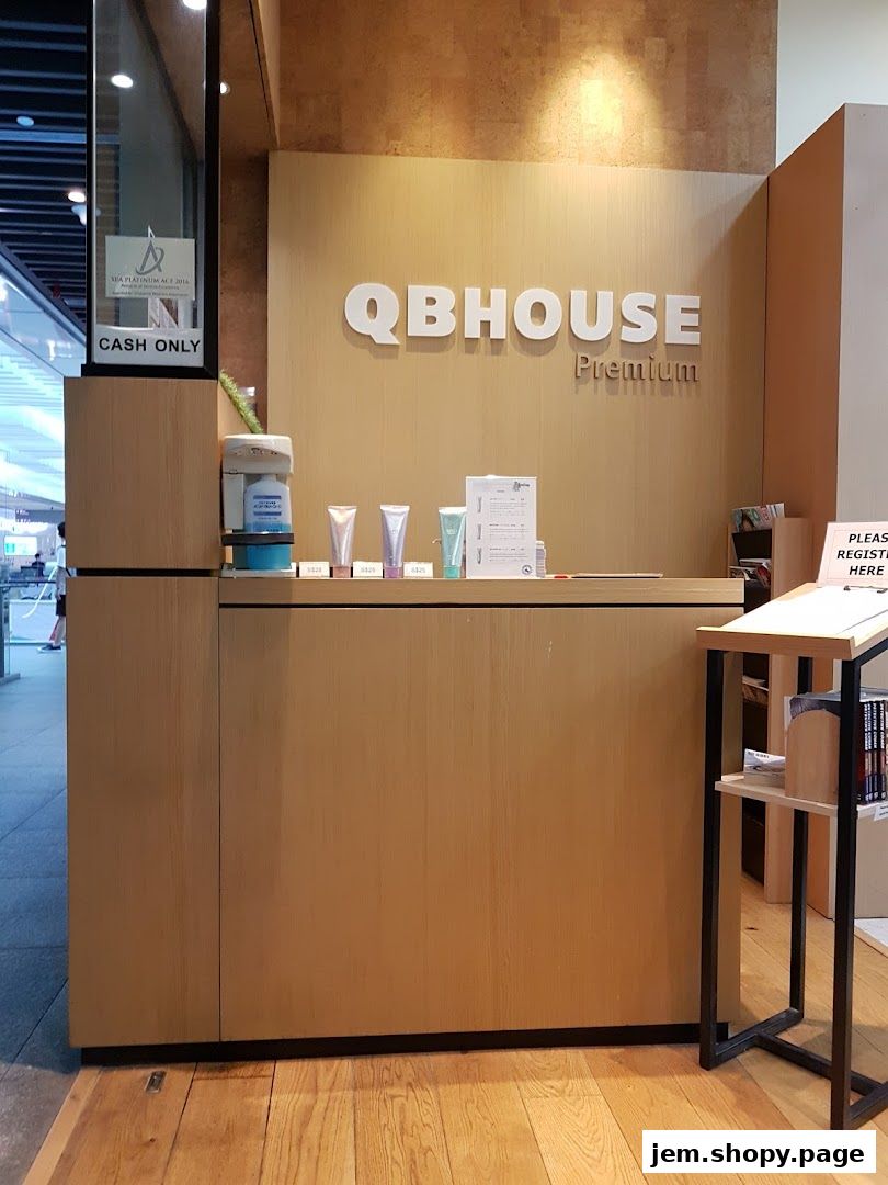 The reception counter of QB Premium Jem, featuring the shop's logo and various products.
