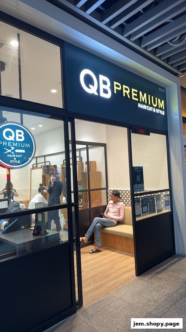 Exterior view of QB PREMIUM HAIR CUT & STYLE shop with barbers at work.