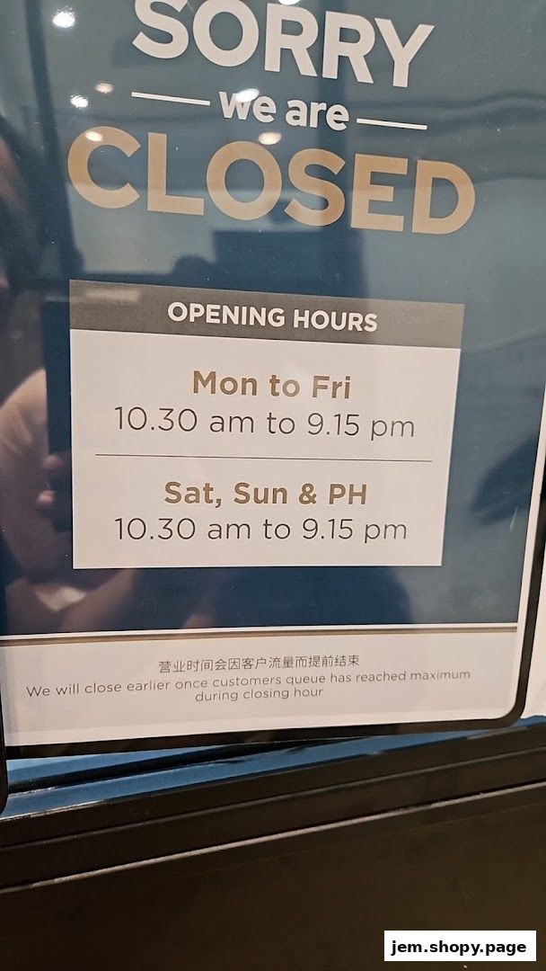 A sign indicating that QB PREMIUM JEM is closed with their opening hours.