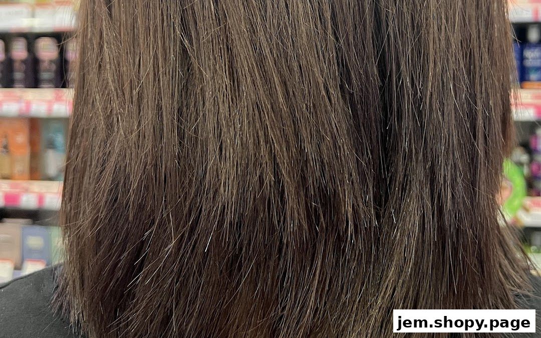 Close-up of dark brown hair with subtle highlights, with shelves of products in the background.
