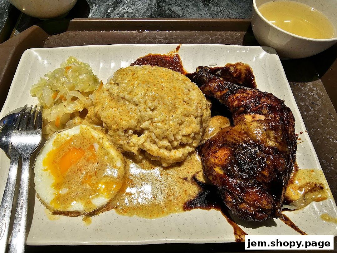 A plate of Indonesian BBQ chicken with rice, fried egg, and pickled vegetables.