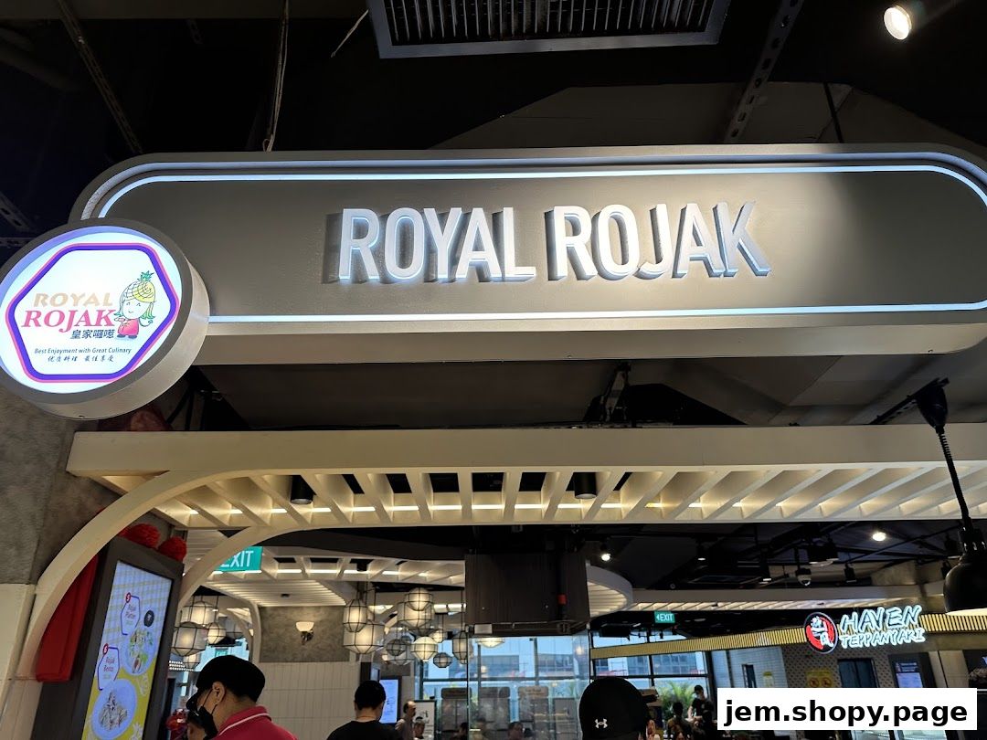 The illuminated sign for Royal Rojak, a food stall in a food court.
