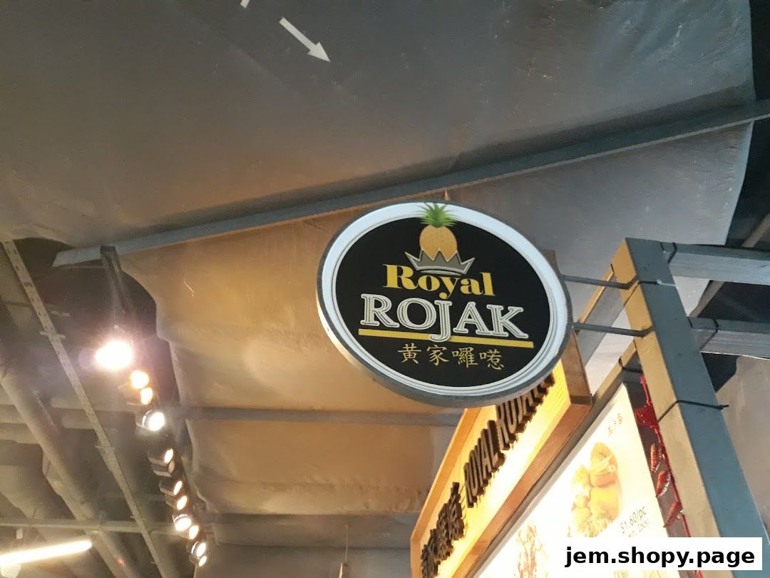 A sign for Royal Rojak Jem Food court L5 with a pineapple logo.