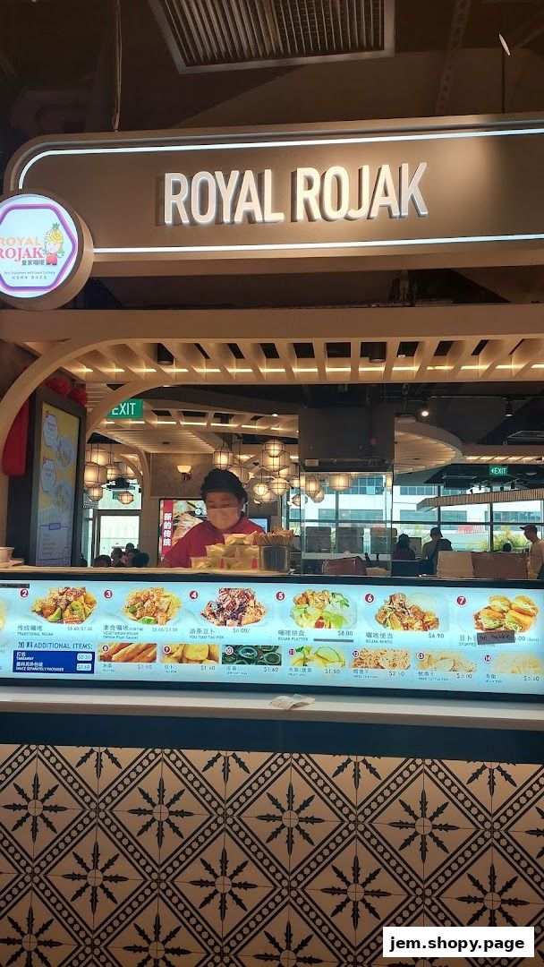 A food stall counter displaying a menu with various rojak dishes and prices.