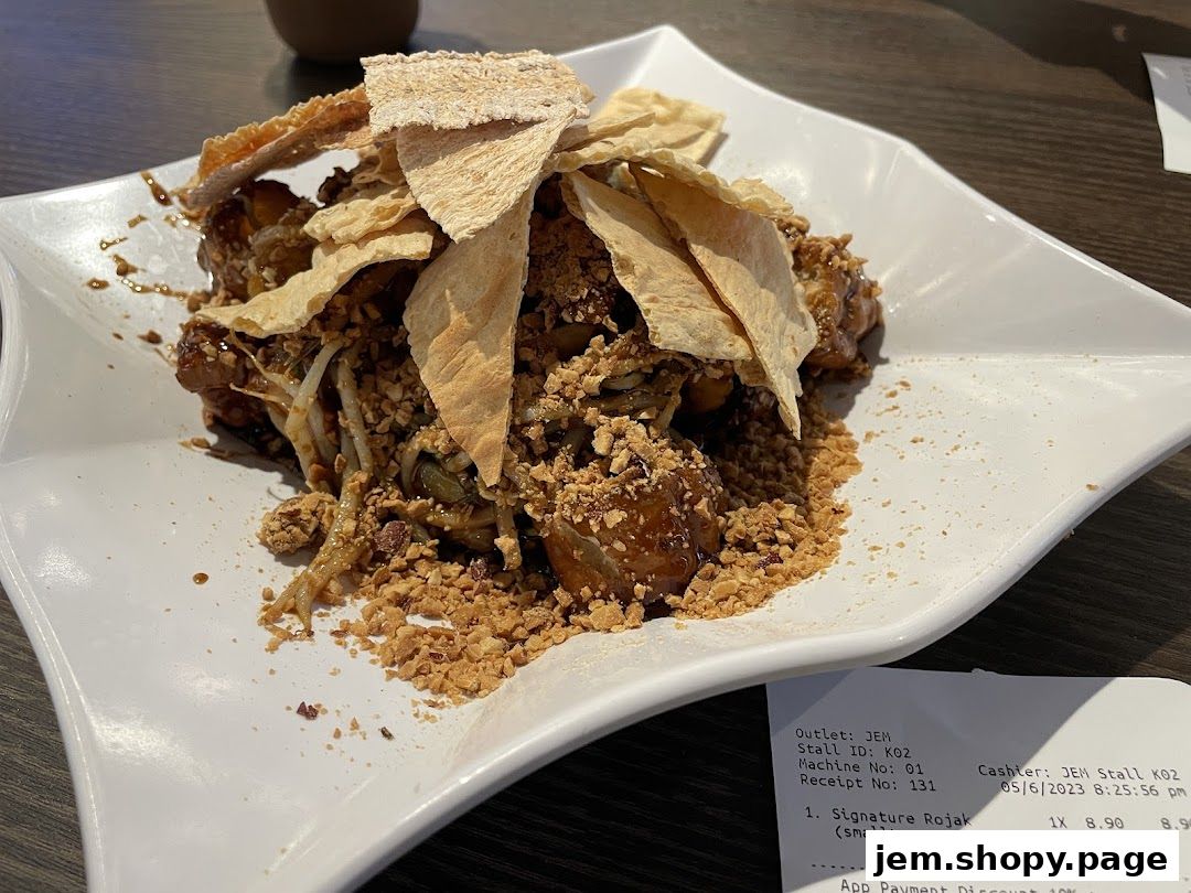 A plate of Rojak topped with crispy crackers and crushed peanuts.