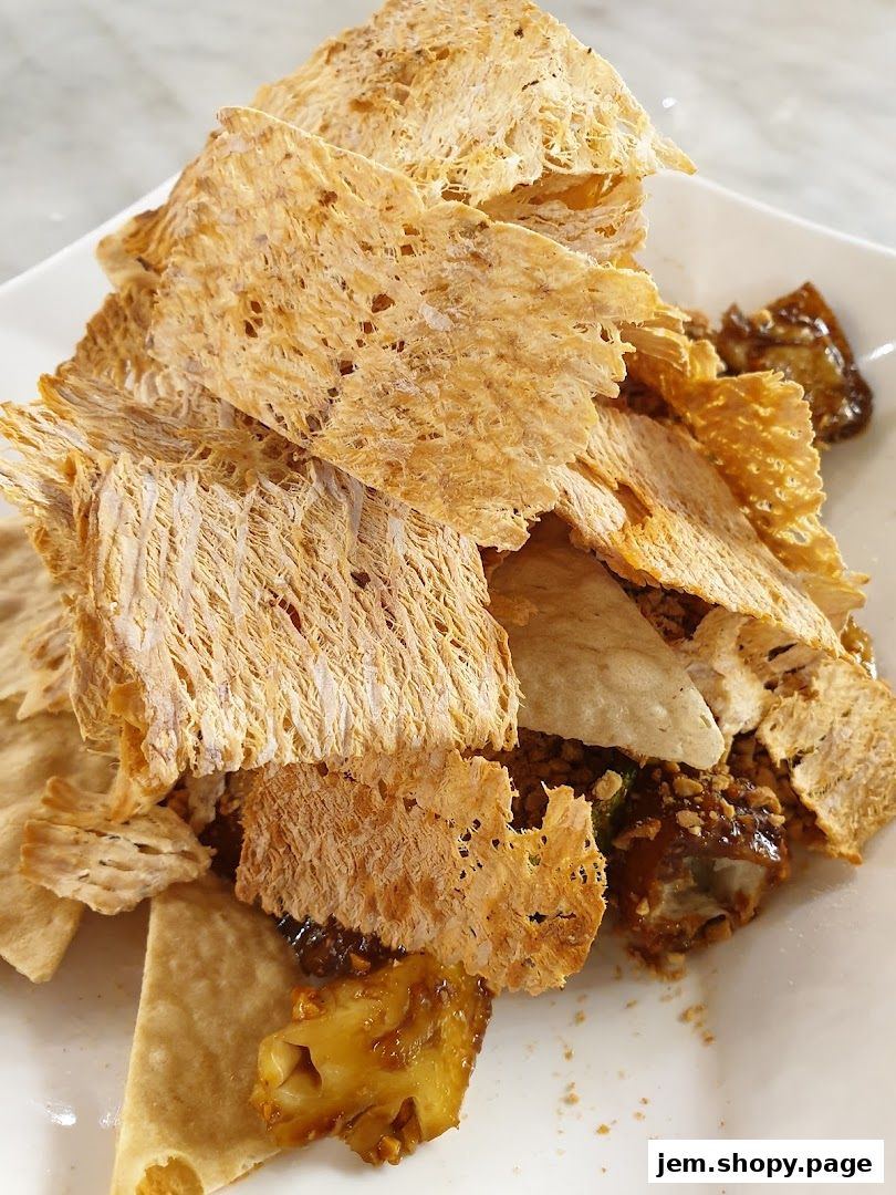A close-up of a delicious Rojak dish with crispy crackers and savory sauce.