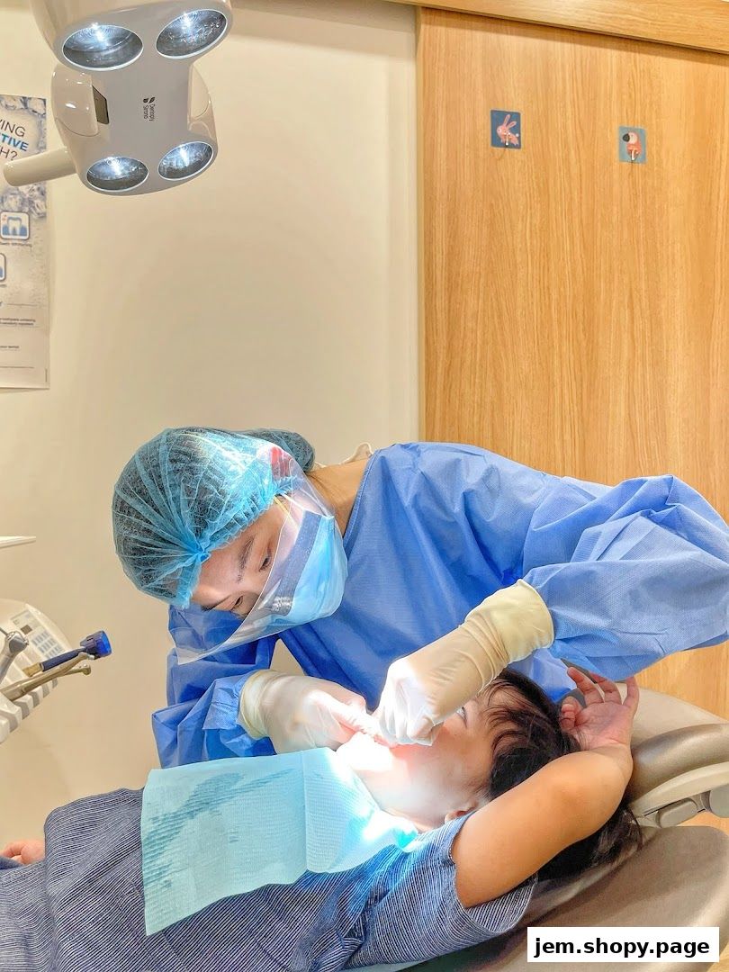 Dentist examining a child's teeth under a bright dental light.