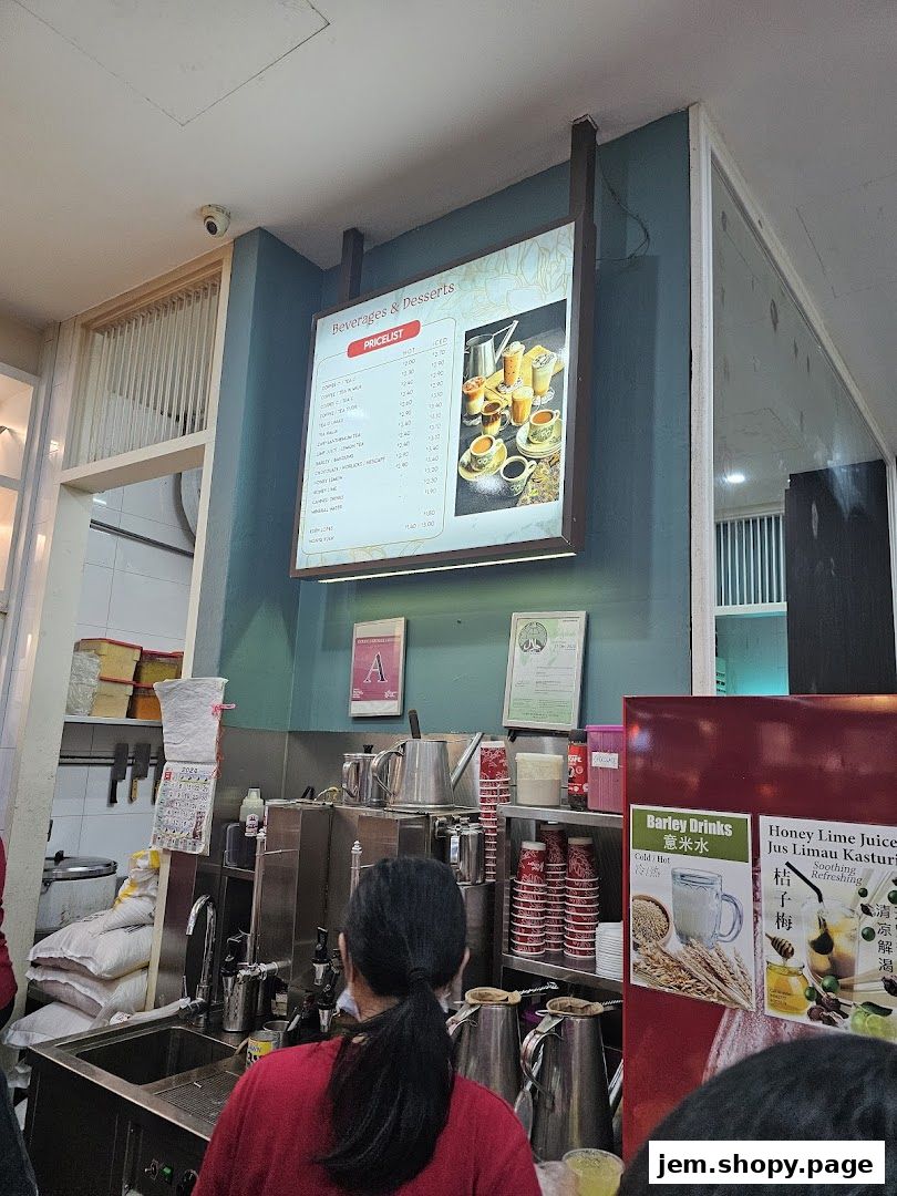 A menu board displaying beverages and desserts with prices, along with promotional posters.