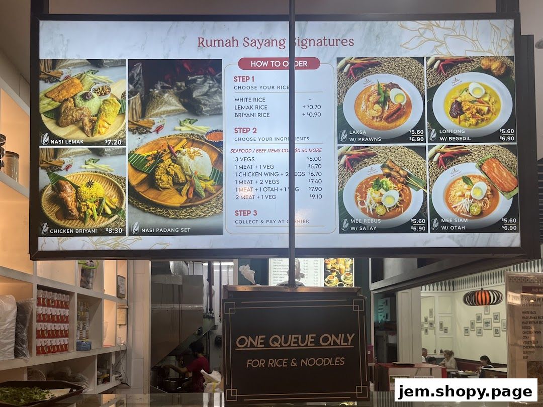 A digital menu board displaying various Malaysian dishes and their prices.
