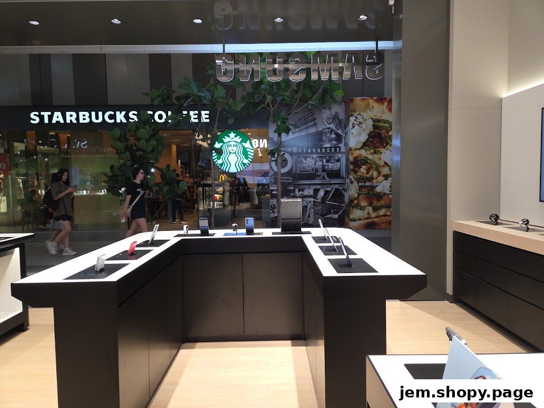 Interior of a Samsung Experience Store with display tables and adjacent Starbucks.