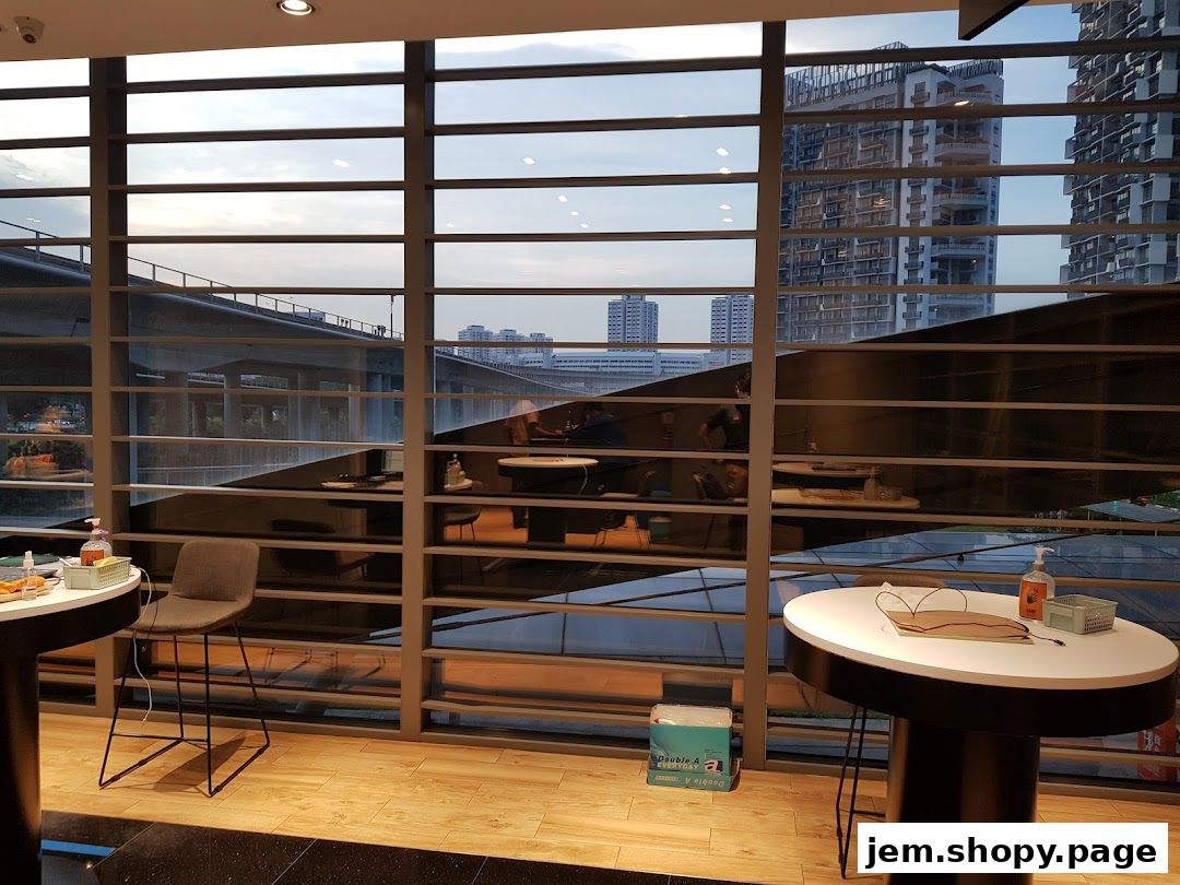 Interior view of a Samsung Service Centre with tables, chairs, and a large window overlooking a cityscape.