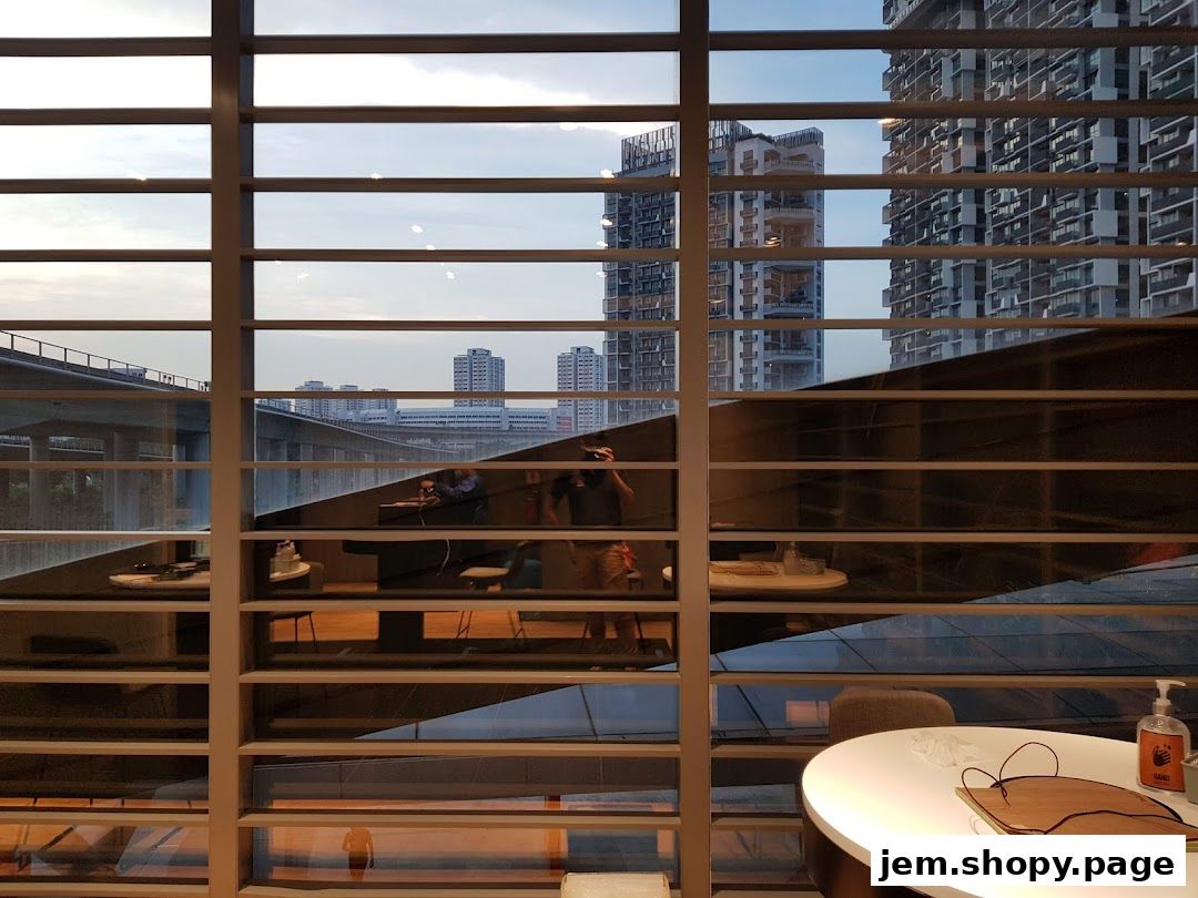 View through a window of a Samsung Service Centre with reflections of people and city buildings.