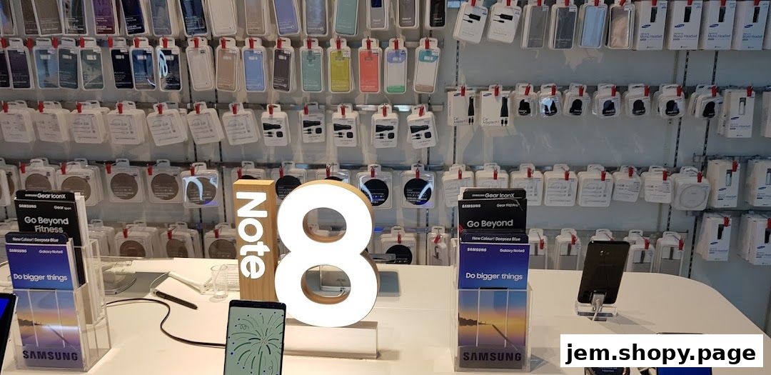 Samsung Note 8 display with accessories and phone cases on the wall.