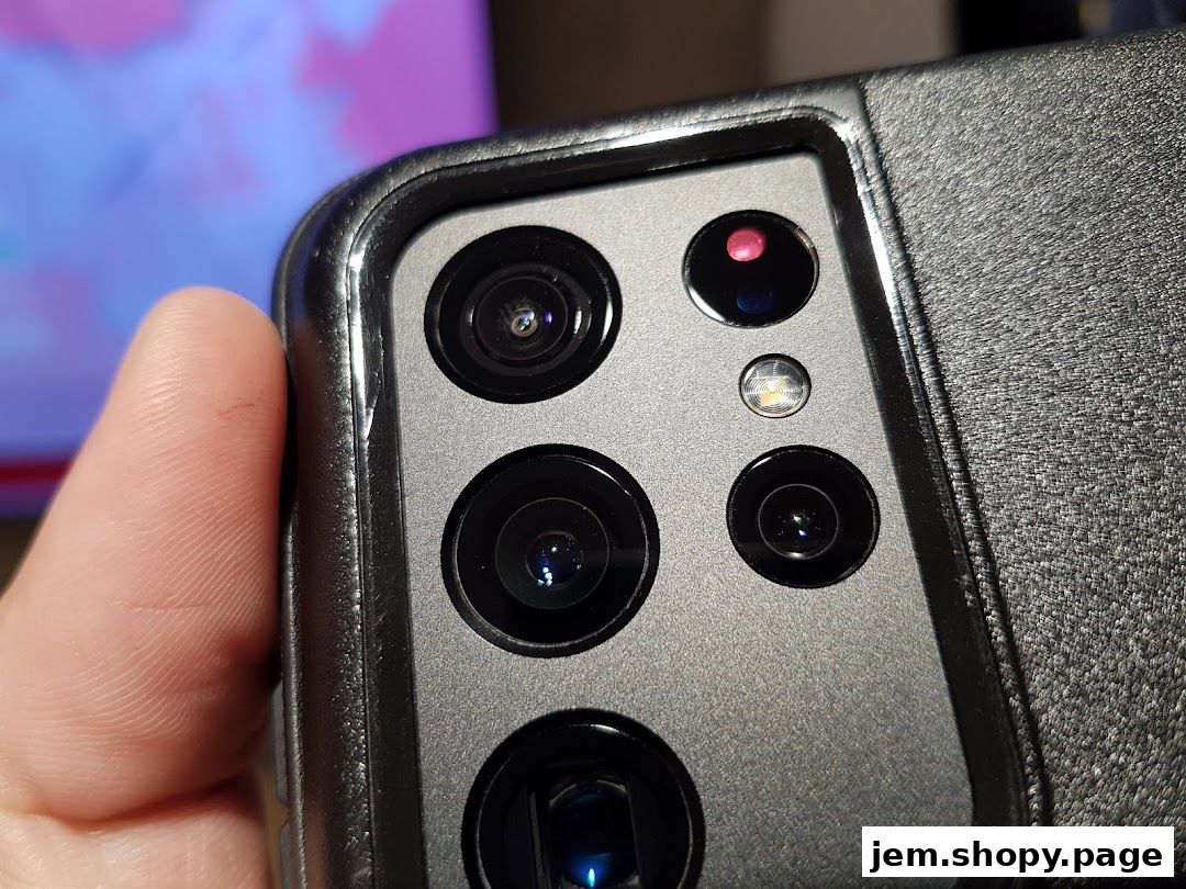 Close-up of a smartphone camera array with a finger on the side.