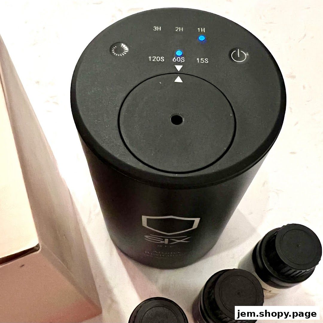 A black diffuser with timer settings and essential oil bottles.