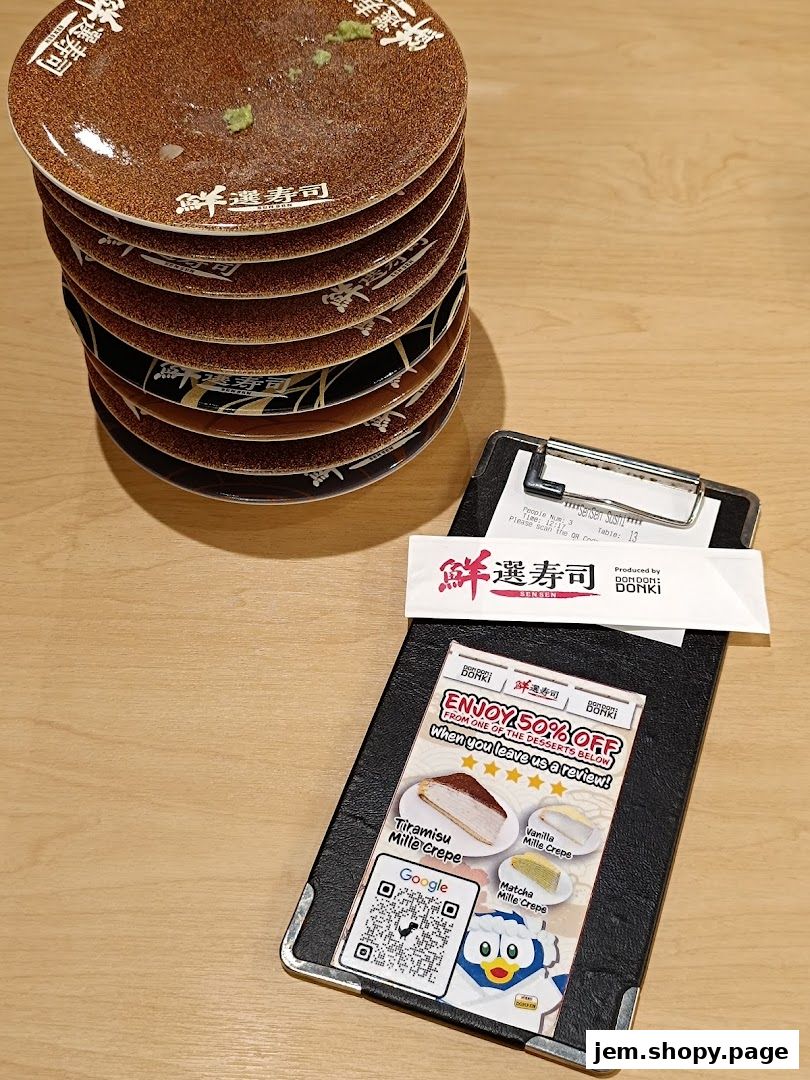 A stack of used sushi plates next to a bill holder with a dessert promotion.