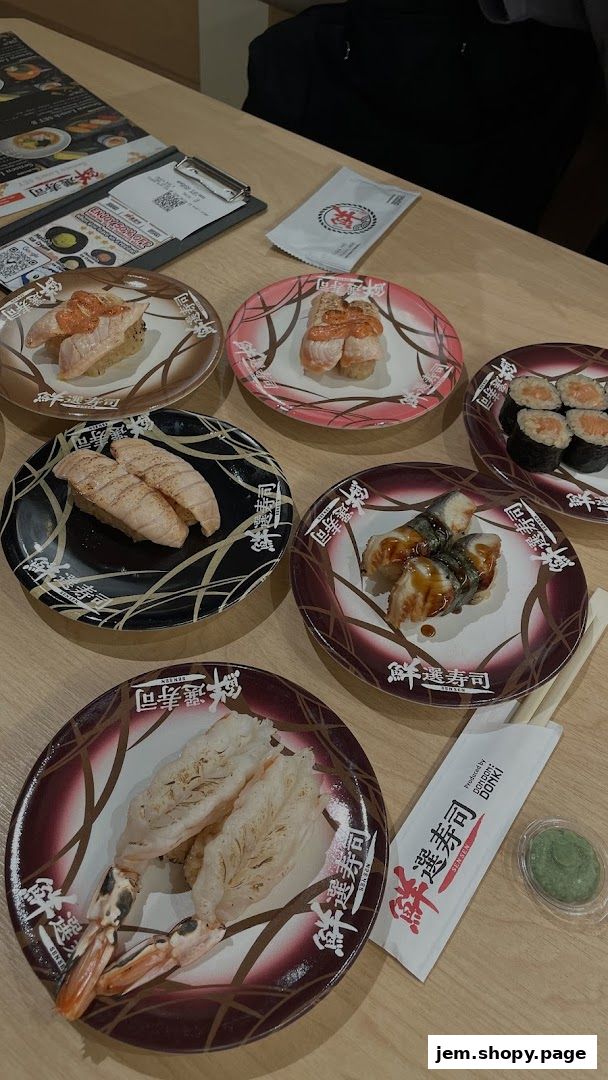 A table filled with various plates of sushi and chopsticks, ready for a meal.