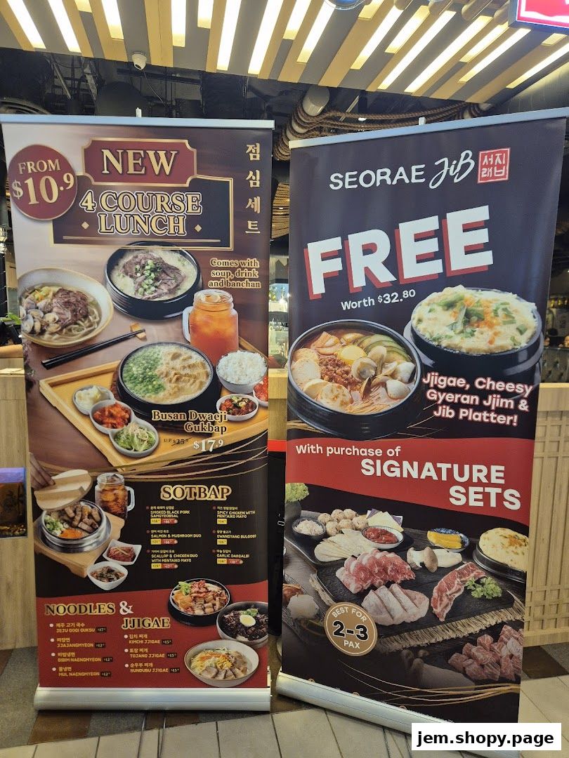 Roll-up banners advertising Korean lunch sets, sotbap, noodles, jjigae, and signature sets.