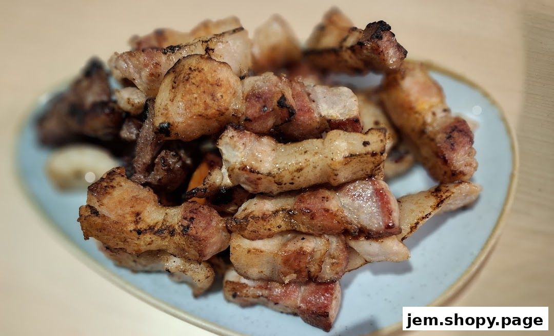 A close-up shot of delicious, grilled pork belly slices on a light blue plate.