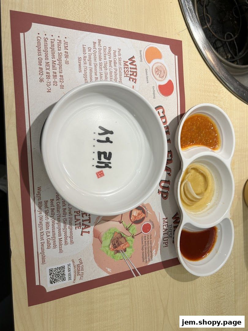 A table setting at Seorae Jib Jem with a bowl, sauces, and a menu featuring Korean BBQ items.