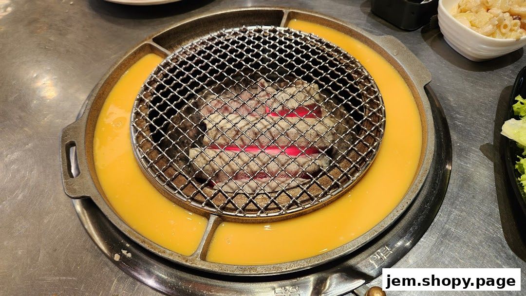 A close-up of a Korean BBQ grill with glowing coals and a moat of cheese.