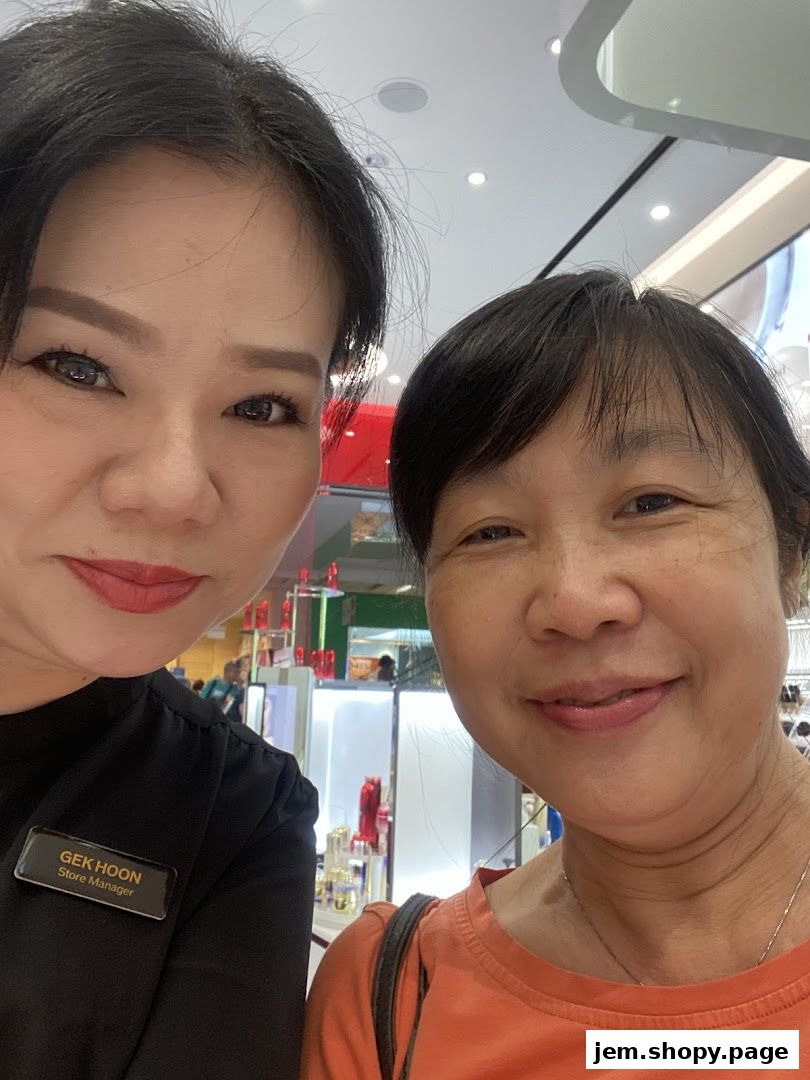 Store manager and customer smiling at the camera inside a Shiseido store.