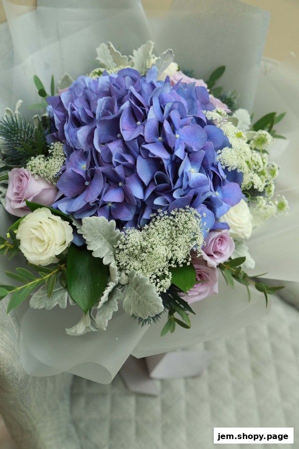 A beautiful bouquet featuring a large blue hydrangea, white and purple roses, and delicate greenery.