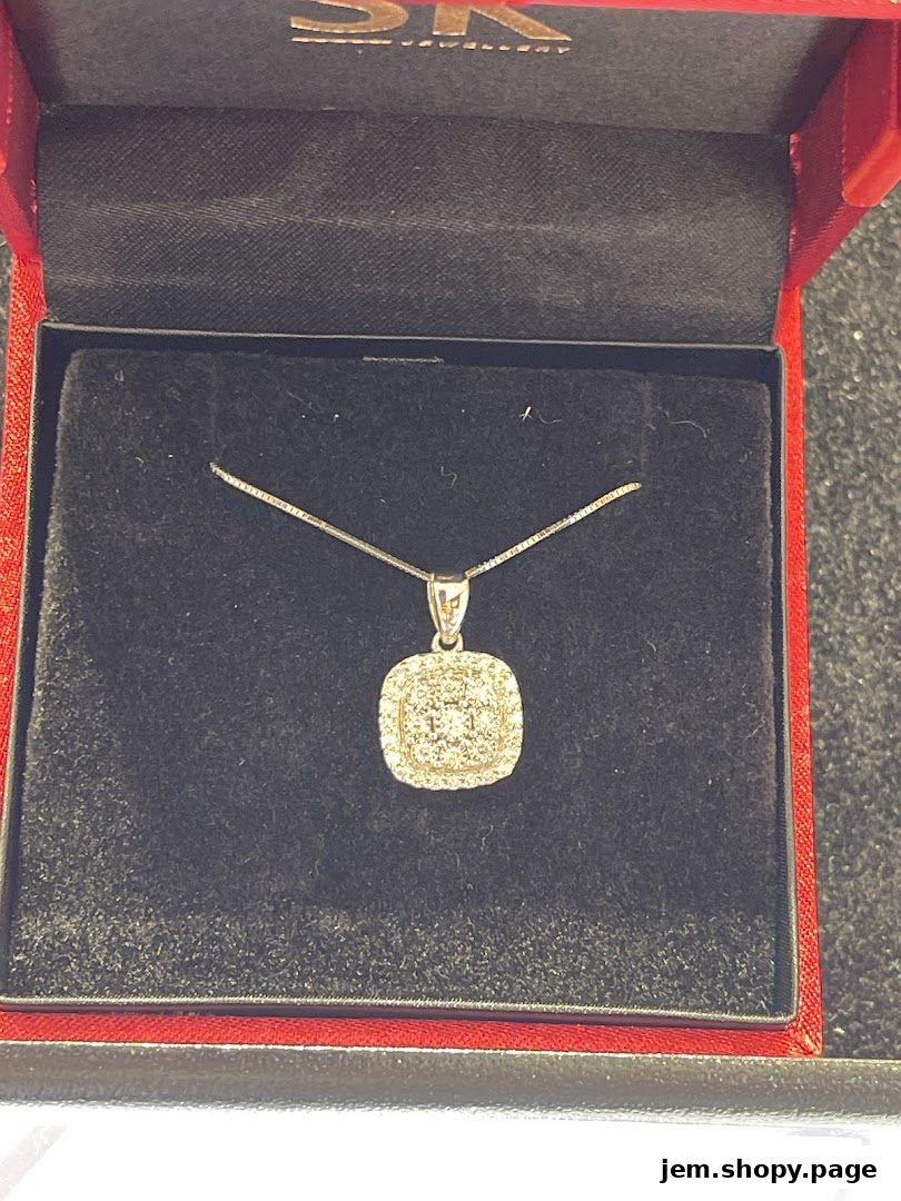 A diamond pendant necklace displayed in a red jewelry box from SK Gold JEM.