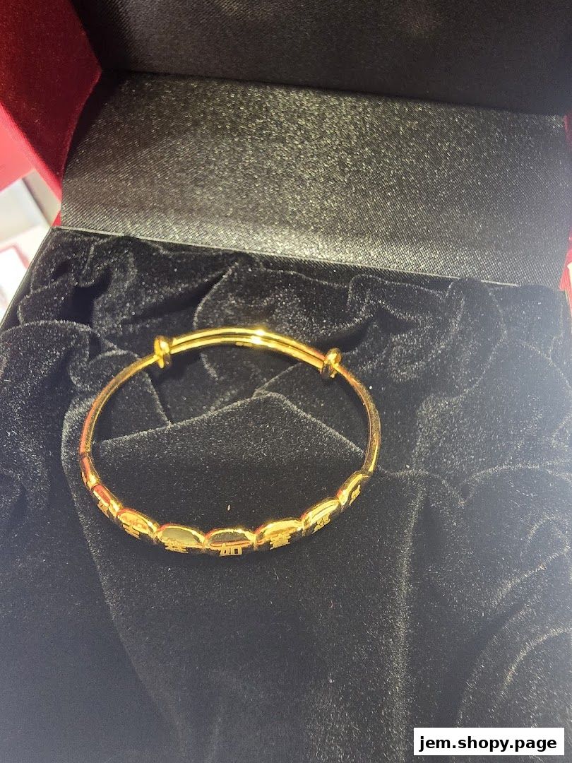 A close-up of a gold bracelet with intricate Chinese characters, presented in a velvet-lined box.