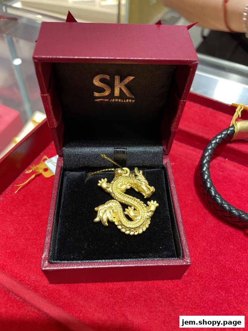 A gold dragon pendant displayed in a SK Jewellery gift box.