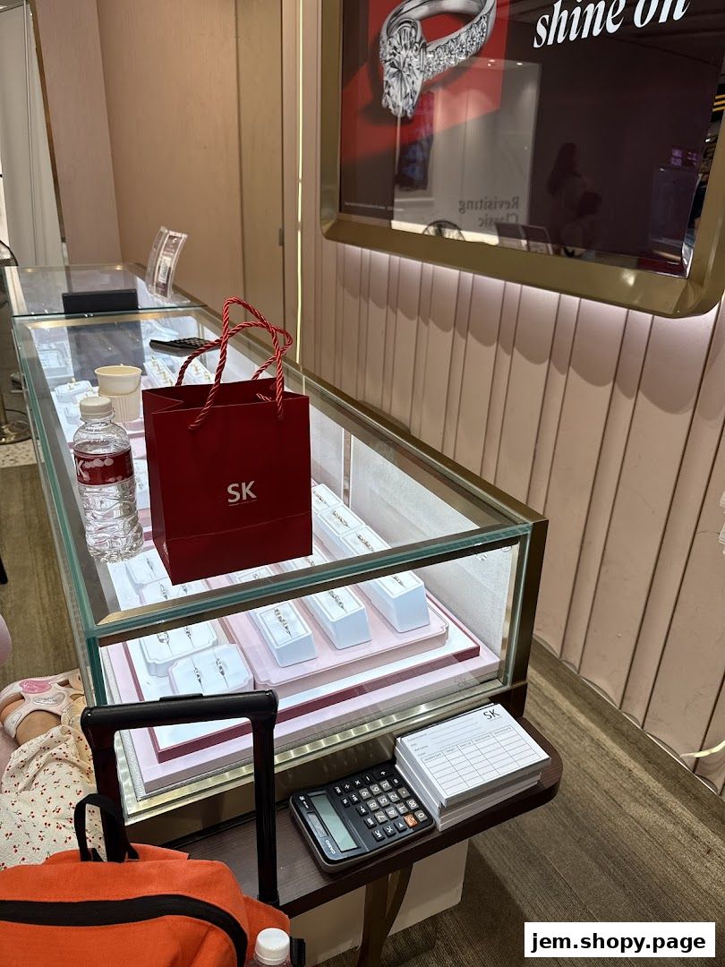 A jewelry display case with rings and a red SK Jewellery bag.