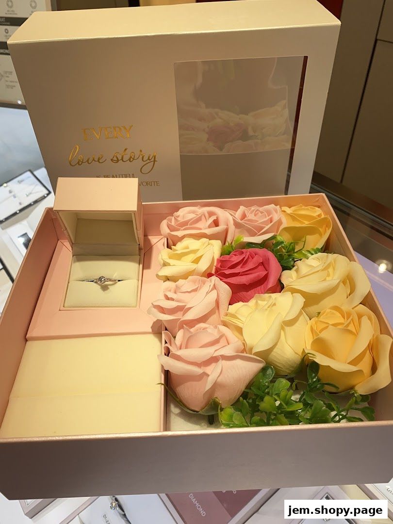 A jewelry box with a ring and artificial roses, with text 'Every love story is beautiful favorite'.