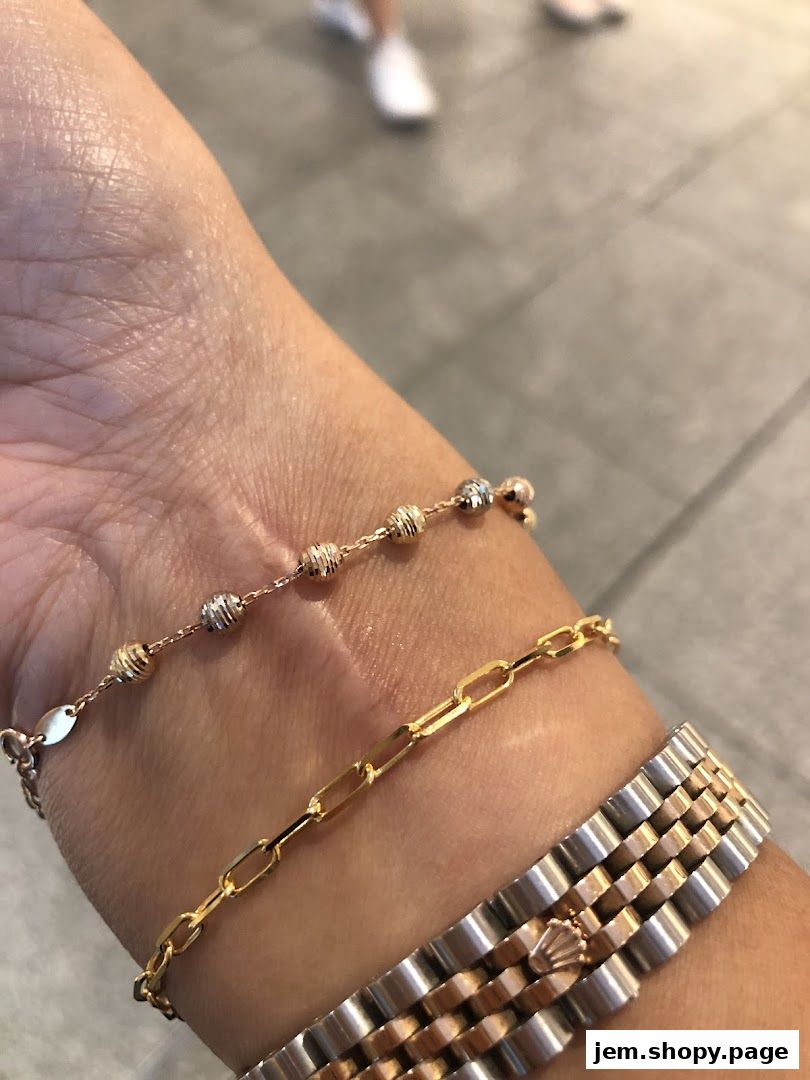 Close-up of a wrist adorned with three elegant bracelets and a watch.