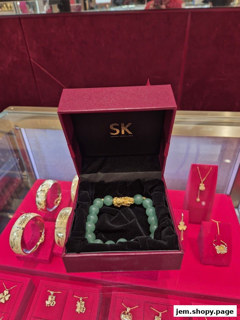 SK Jewellery Jem showcases a jade bracelet with a gold clasp and other gold jewelry.