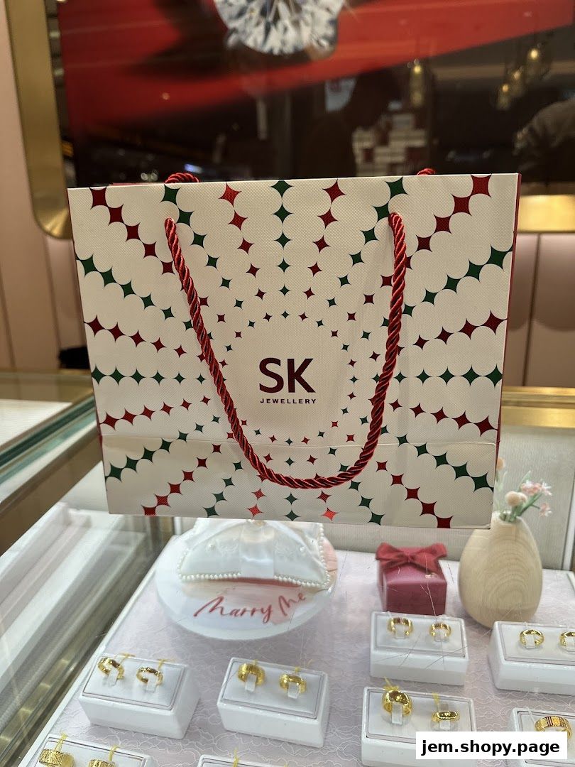 A shopping bag from SK Jewellery with rings displayed in a jewelry case.