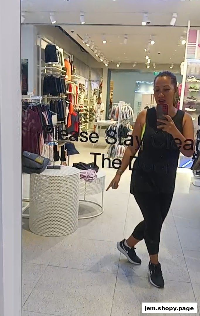 A woman takes a mirror selfie inside a Skechers store, showcasing apparel and footwear.