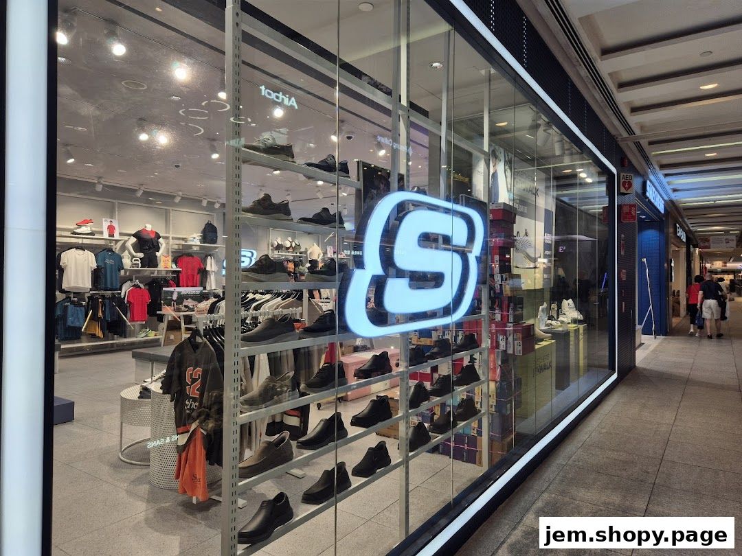 Skechers store window display featuring shoes and apparel, with a large illuminated S logo.