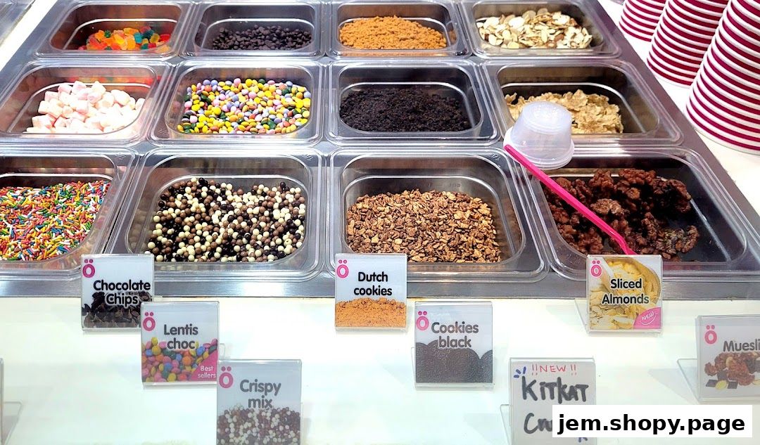 A display of various toppings for frozen yogurt or ice cream, including candies, nuts, and cookies.