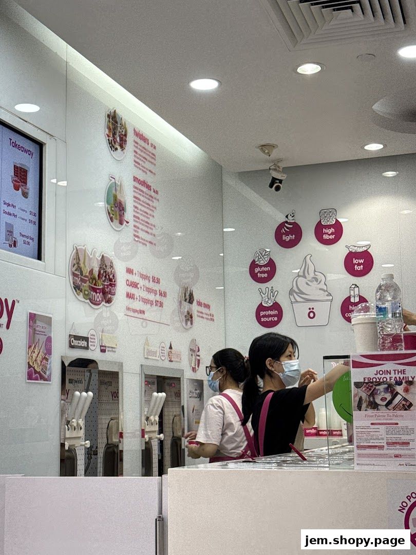 Staff serving frozen yogurt at a smöoy shop with menu boards and dispensers.
