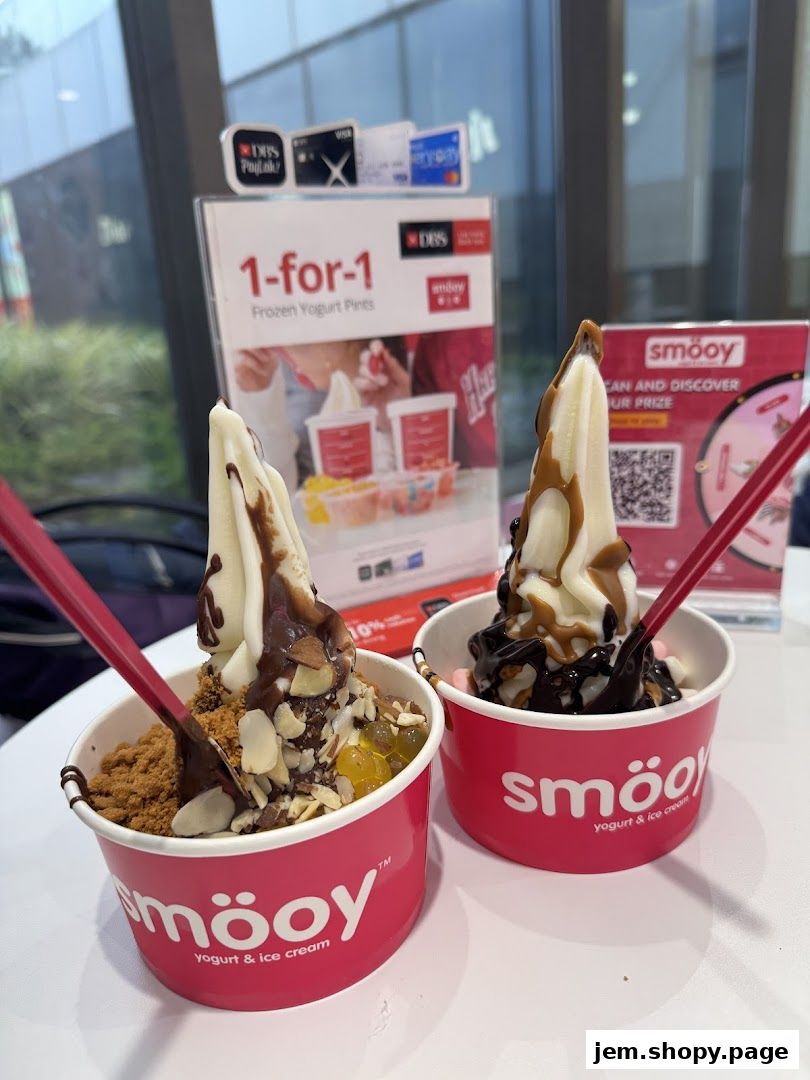 Two cups of frozen yogurt with various toppings and sauces from Smooy.