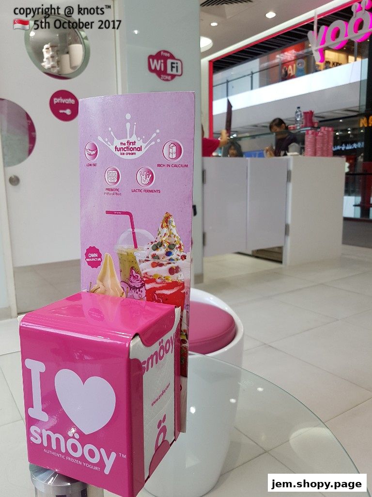 A pink box with 'I love smooy' and a menu stand for frozen yogurt.