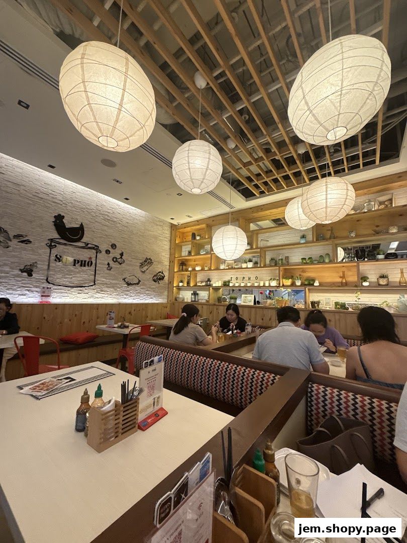 Interior of a Vietnamese restaurant with customers dining and decorative lanterns.