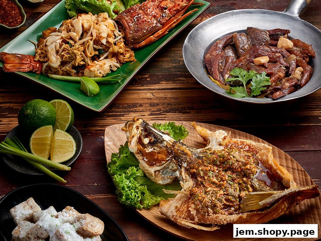 A spread of delicious Thai dishes including lobster pad thai, fried fish, and duck feet.