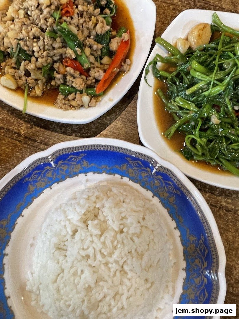 A plate of white rice served with two dishes of Thai food.